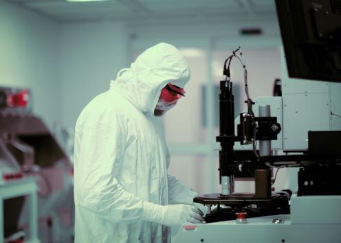 Gowned researcher fabricating device in KU Nanofabrication Facility