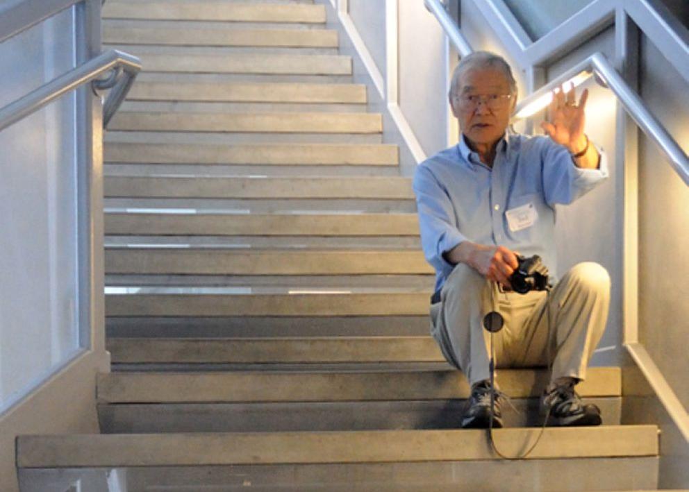 Ted Kuwana sitting on stairs in research building