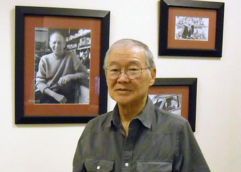 Ted Kuwana in front of photos at Adams Institute